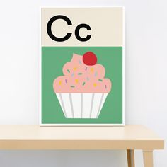 a cupcake with sprinkles and a cherry on top is displayed in front of a white wall