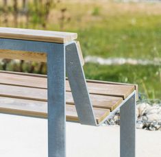 a wooden bench sitting on top of a cement ground