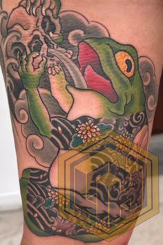 a close up of a person's leg with a tattoo on it and an image of a frog