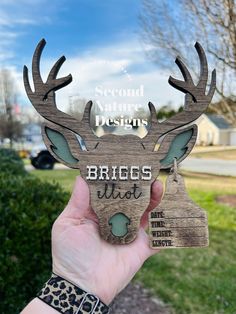 a person holding up a wooden sign that says, second nature designs briegs west