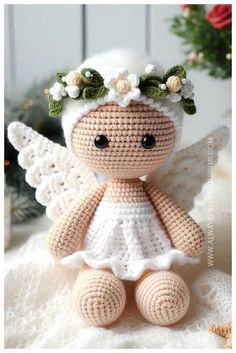 a crocheted angel sitting on top of a white blanket