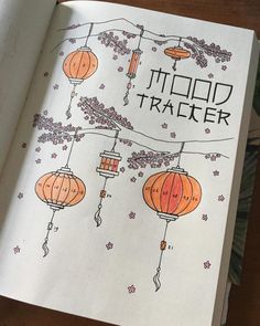 an open book with chinese lanterns hanging from it's sides and the words tidd trader written in black ink