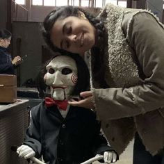 two people are posing for a photo while one person is sitting on a bike and the other has a creepy mask