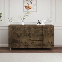 a wooden cabinet with two vases on top of it in front of a white wall