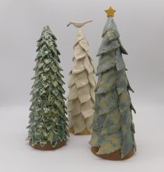 three ceramic christmas trees sitting next to each other