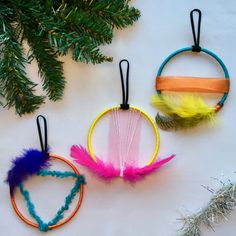 three different colored feathers hanging from strings