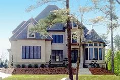 a large white house sitting on top of a lush green field