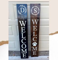 two wooden welcome signs sitting next to each other on the side of a garage door