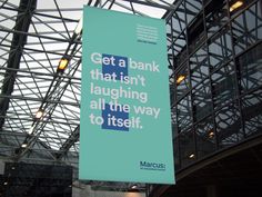 a sign hanging from the side of a building that says get a bank that isn't laughing all the way to itself