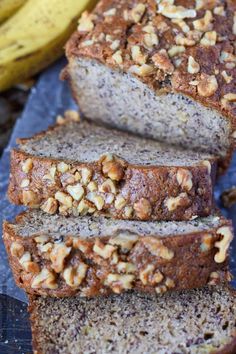 sliced loaf of banana nut bread on top of a cutting board next to two bananas