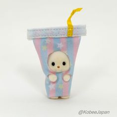 a small stuffed animal in a striped cup