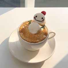 there is a small toy in the middle of a cup of cappuccino