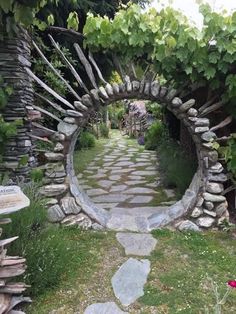 a stone arch in the middle of a garden