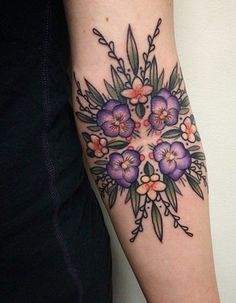 a woman's arm with flowers on it and the words tattoo written in black ink