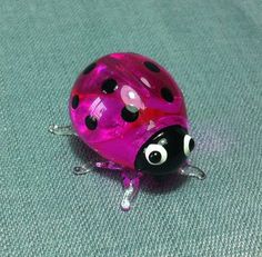 a pink lady bug sitting on top of a blue surface