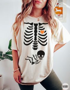 "Skeleton Halloween Maternity Clothes, Funny Pregnancy Announcement Shirt 2023, Pregnant Women Costume, Fall New Mom TShirt, Mommy to Be Gift Idea, Expecting Mama Outfit, Gift for Pregnant Wife, Sister, Daughter, or Friend ✧ WHY  YOU'LL  LOVE IT ✧  ⋒ Comfort Colors® tees are garment-dyed shirts that are timeless classics and will never pile.  ⋒ Trendy retro vintage look and gorgeous colors.  ⋒ Amazingly soft and comfy. Perfect with any shorts, skirts, jeans, leggings, or nothing but undies aroun Halloween Maternity Costumes, Maternity Halloween Costumes Couples, Halloween Pregnancy Costumes, Pregnant Halloween Costumes Small Bump, Halloween Costumes For Pregnant Women, Pregnancy Halloween Costumes, Baby Girl Pregnancy Announcement, Pregnant Costume, Pregnant Halloween Costume