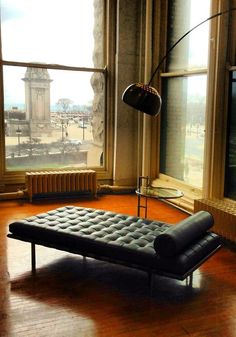 a black leather chaise lounge in front of a window