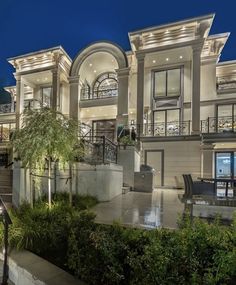 a large house with many windows and balconies on the front porch at night