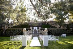 an outdoor ceremony setup with white chairs and flowers