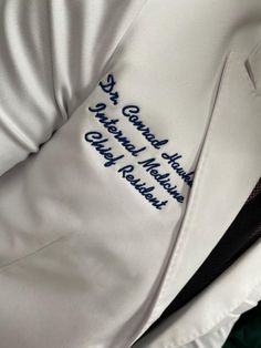 a close up view of a white jacket with blue writing on the front and back