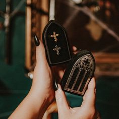 a person holding a small black box with a cross on it's lid and the other hand