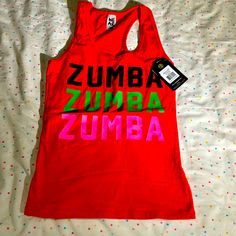 Zumba Racerback Tank Top Size - Xs Brand New With Tags Red Cotton Tank Top With Letter Print, Red Casual Tank Top For Streetwear, Casual Red Tank Top With Letter Print, Red Cotton Gym Top, Red Fitted Tank Top For Streetwear, Red Cotton Sporty Tank Top, Trendy Red Tank Top For Streetwear, Red Cotton Tops For Gym, Red Cotton Racerback Tops