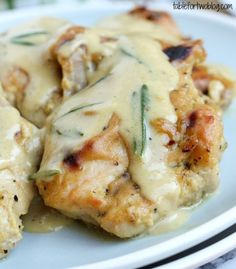 chicken covered in gravy on a white plate