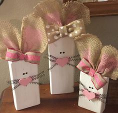 three small wooden blocks with hearts and bows