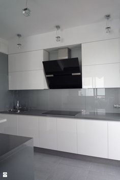 an empty kitchen with white cabinets and black counter tops on the wall above the sink