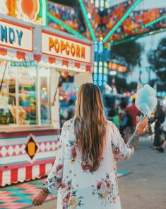 a woman standing in front of a carnival ride