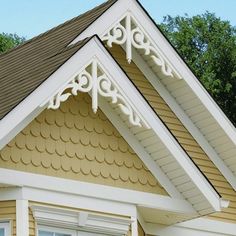 the corner of a yellow house with white trim