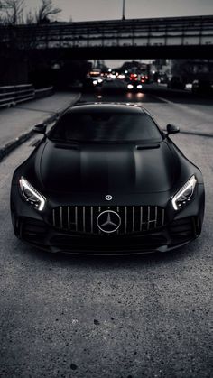 a black sports car parked in front of a bridge