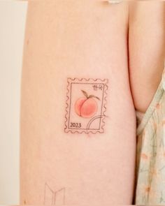 a small peach stamp on the back of a woman's right arm