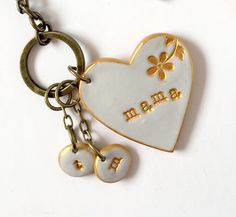 a heart shaped keychain with two charms attached to it