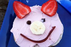 a cupcake shaped like a pig with strawberries on it's ears and nose