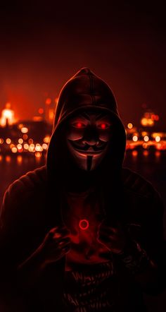 a person wearing a mask and holding a cell phone in their hands with the lights on