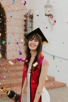 a woman wearing a graduation cap and gown with confetti in front of her