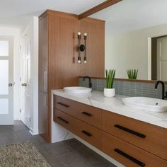 a bathroom with double sinks and wooden cabinets