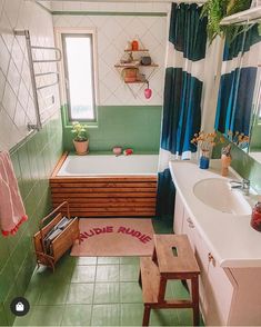 a bathroom with green and white walls, tile flooring and a bathtub in the corner