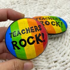 two rocks with the words teachers rock painted on them are being held by someone's hand