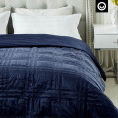 a bed with blue comforter and white pillows