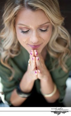 a woman with her hands clasped in prayer