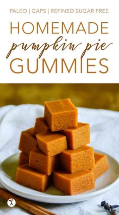 homemade pumpkin pie gummies stacked on a plate with cinnamon sticks in the foreground