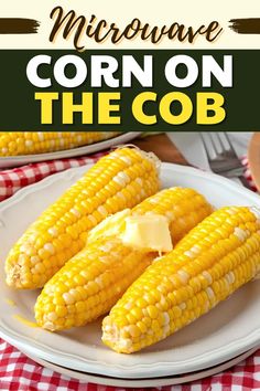 corn on the cob with butter and parmesan cheese is sitting on a white plate