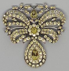 Fashion in terms of jewelry in the 17th and 18th century in France is certainly the Bow.  Gilles L'Egaré one of the finest jewelry maker of Louis XIV's century created the L'Egaré bow. It is a brooch in shape of a double ribbon bow , usually made of gold or silver, diamonds and precious stones. It was pined on the woman top, centrally position to attract the eye. Madame de Sévigné is certainly the most well known lady to wear this bow. This brooch is a true replica of the one you can admire in M Double Ribbon Bow, 17th Century Fashion, Georgian Jewelry, Woman Top, Bow Brooch, Double Bow, Louis Xiv, Ribbon Bow, Jewelry Maker