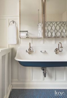 a bathroom sink sitting under a mirror next to a radiator and towel dispenser