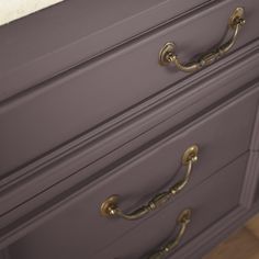 a close up of a dresser with brass handles