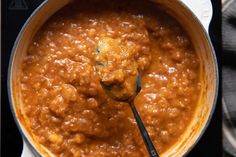 a ladle full of food is being held by a spoon