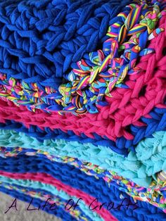 a pile of colorful knitted blankets sitting on top of each other