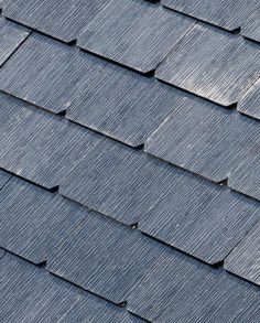 a close up view of a roof that has been shingled with dark blue tiles